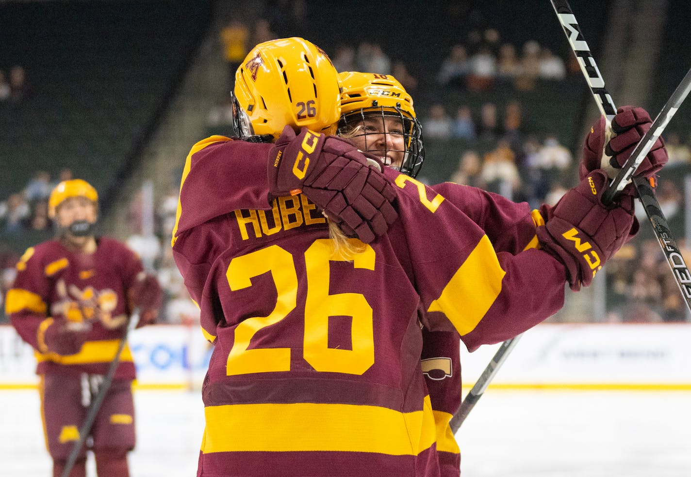 Minnesota forward Ella Huber (26) is embraced by forward Abbey Murphy (18) after scoring the team's seventh goal on St. Thomas goaltender Calla Frank (32) in the third period Friday, Oct. 13, 2023, at Xcel Energy Arena in St. Paul, Minn. The Gophers would go on to win 8-0. ]