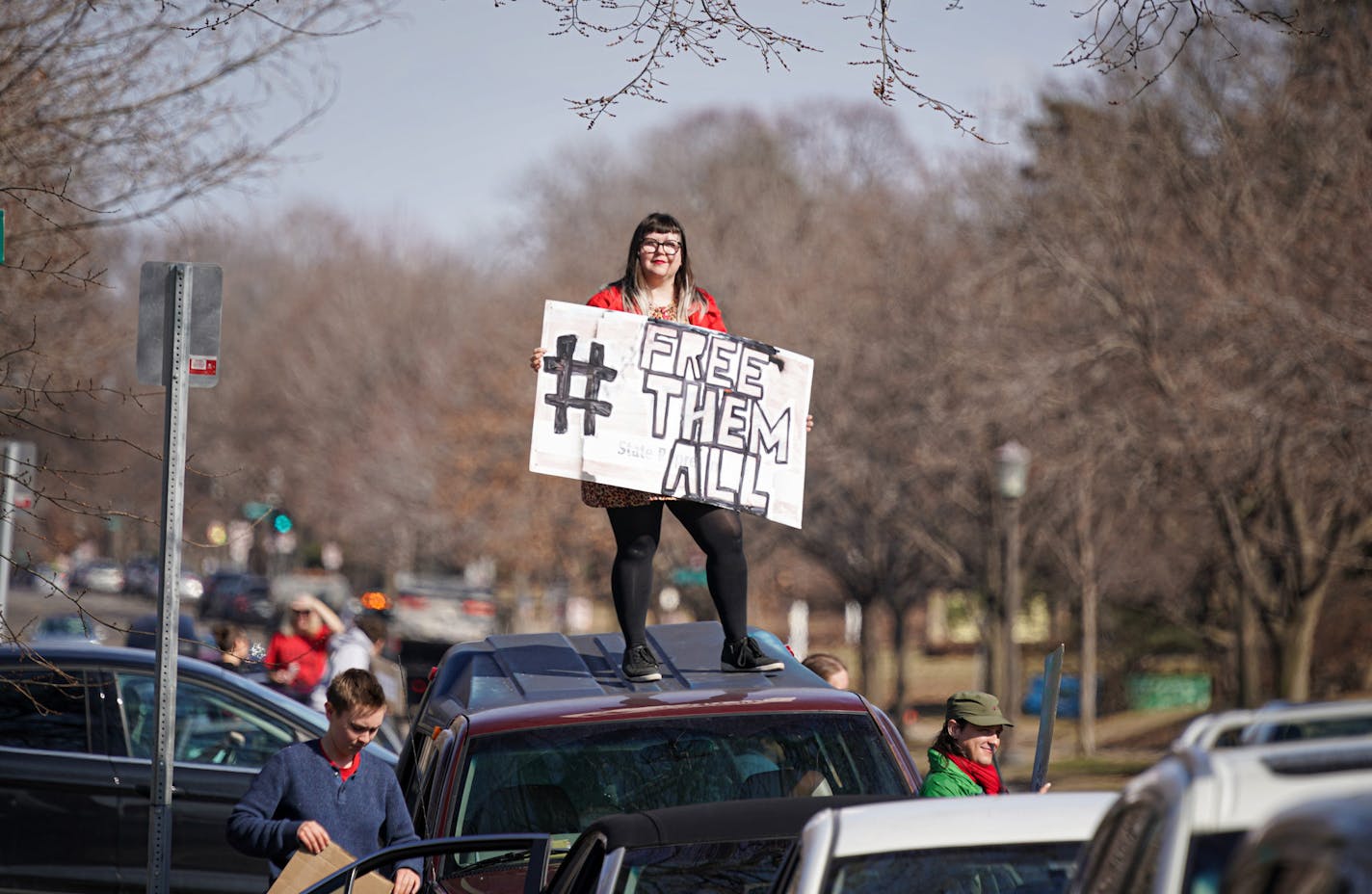 Nickey Robo stood on the roof of her vehicle, joined other activists who stayed mostly in their cars for social distancing, as the lined Summit Ave, honking horns outside the Governor's Residence in St Paul. The were calling for the release of high risk prisoners and ICE detainees from MN facilities to lower the chances of infection. ] GLEN STUBBE &#x2022; glen.stubbe@startribune.com Friday, March 27, 2020