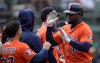 Houston Astros' Yordan Alvarez, right, is congratulated by teammates after hitting a home run during the ninth inning of a baseball game against the O