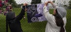 Mary Nye and Laura Menard hung artwork on the fence at Paisley Park in Chanhassen.