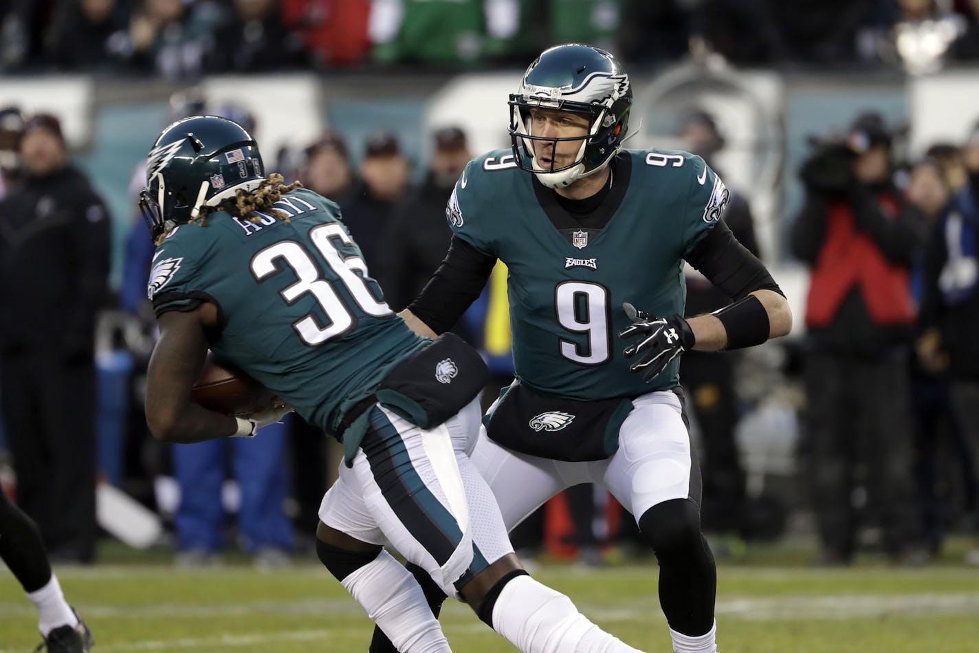 Philadelphia Eagles' Nick Foles, right, hands off to Jay Ajayi during the first half of an NFL divisional playoff football game against the Atlanta Falcons, Saturday, Jan. 13, 2018, in Philadelphia. (AP Photo/Michael Perez)