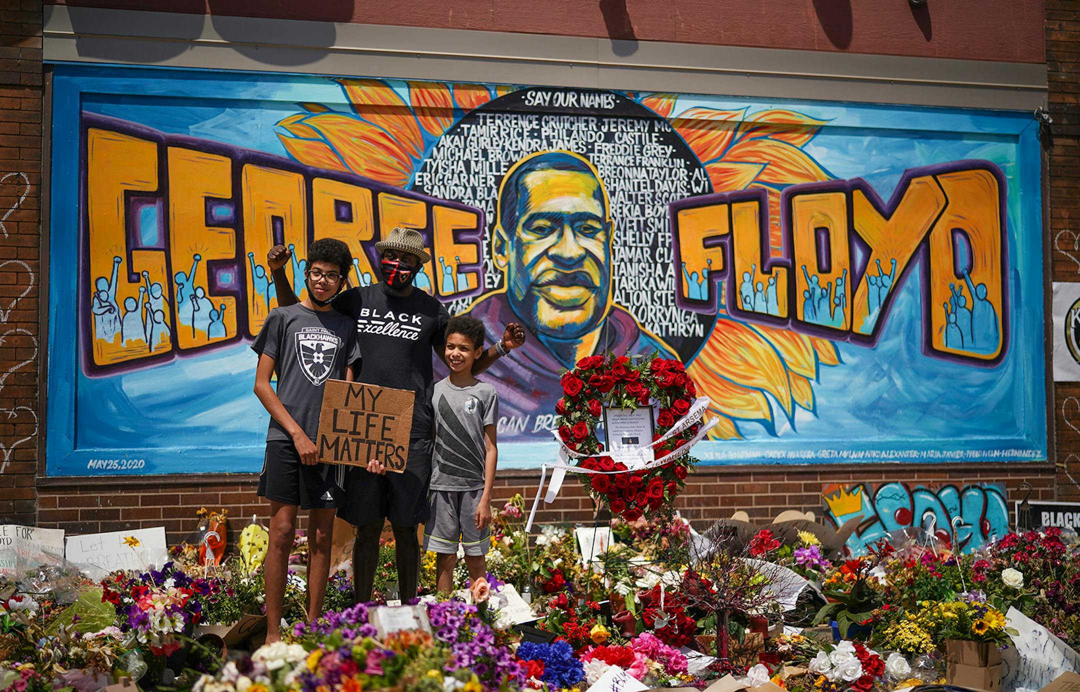 Lahens St. Fleur posed for a photo with his sons Antonio, left, and Andre on Sunday, June 7, at the memorial for George Floyd in Minneapolis. The family is from St. Paul.