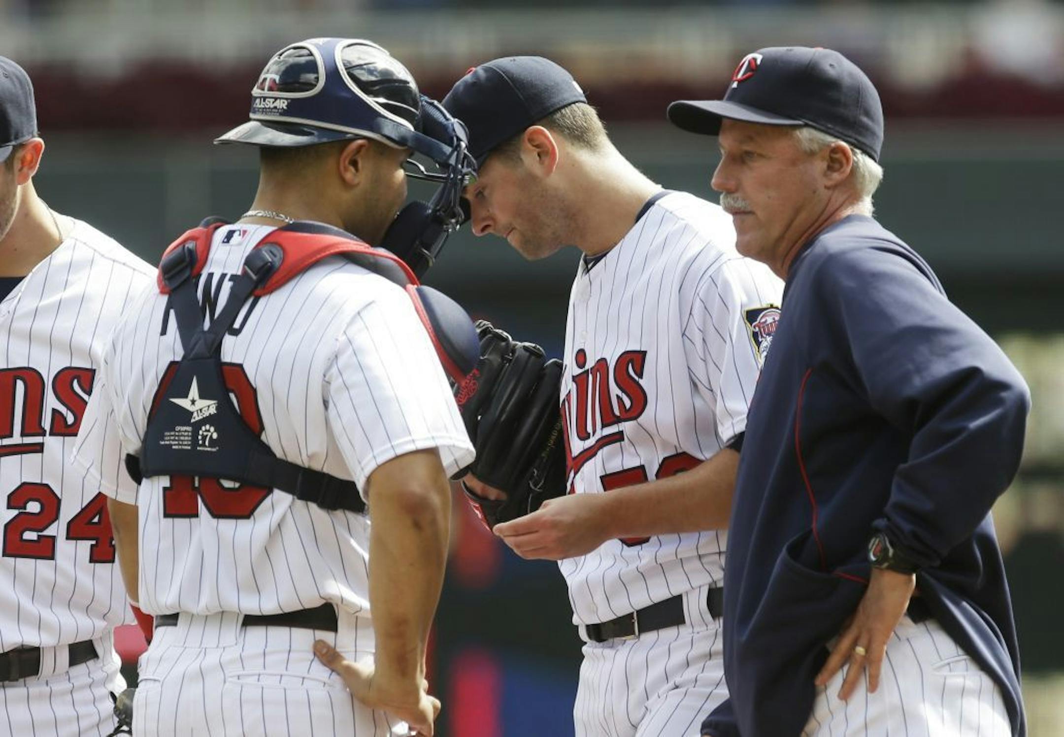 Minnesota Twins pitcher Scott Diamond, center, gets a visit by pitching coach Rick Anderson, right, and catcher Josmil Pinto after giving up a run on a RBI single by Oakland Athletics' Jed Lowrie in the third inning of a baseball game, Thursday, Sept. 12, 2013 in Minneapolis.