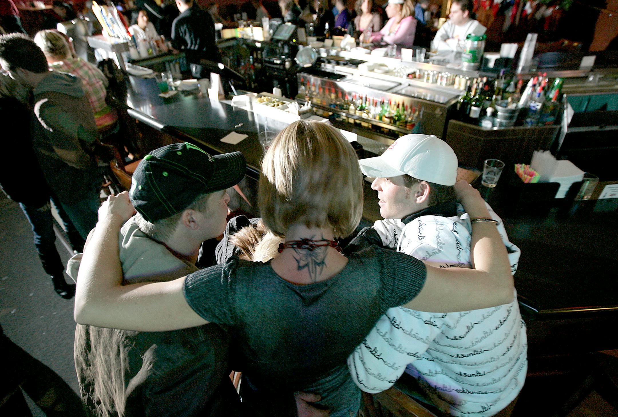Laura Nelson, 25, of Shakopee, center, hugged friends at the Time Out Sports Bar in Blaine on Thursday night. Asked why she comes all the way from Shakopee to Blaine to go to the bar, she replied: "This is my Cheers."
