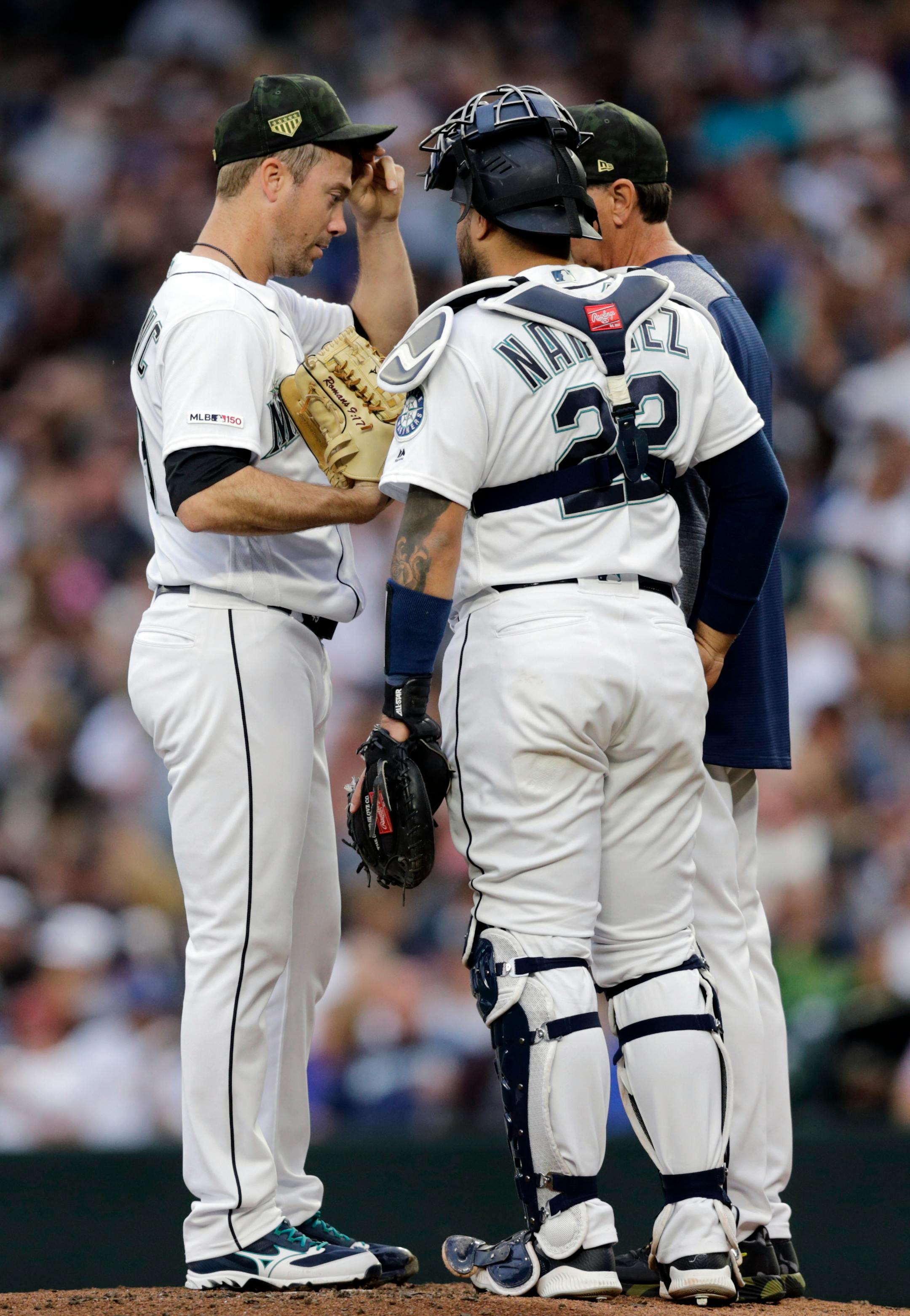 Seattle Mariners starting pitcher Wade LaBlanc, left, talks on the mound with catcher Omar Narvaez and pitching coach Paul Davis during the second inning against the Minnesota Twins in a baseball game Saturday, May 18, 2019, in Seattle. (AP Photo/John Froschauer)