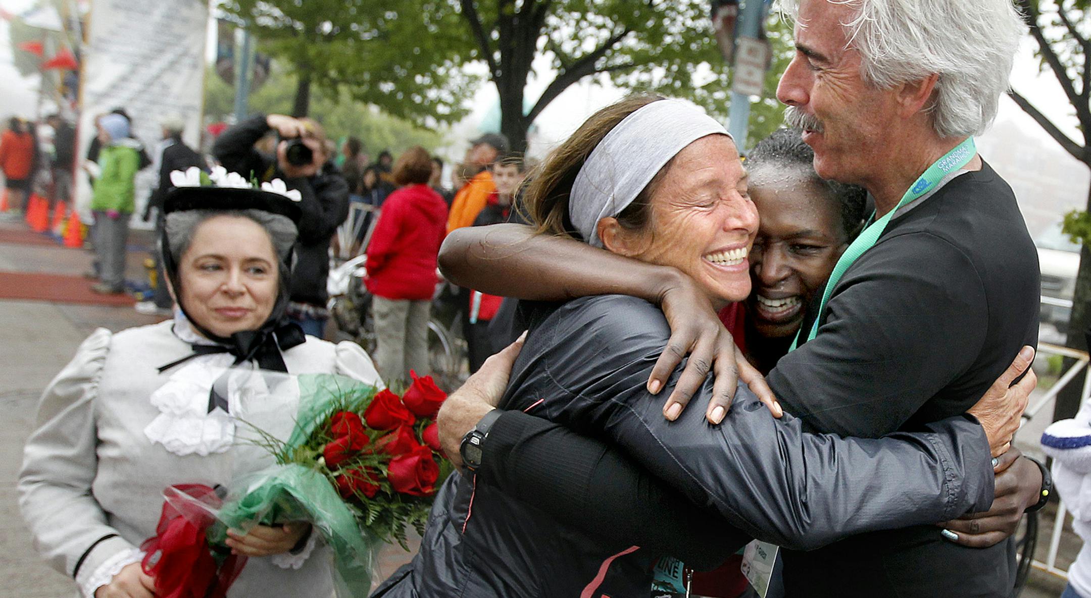 Grandma’s Marathon women’s winner Sarah Kiptoo, middle right, got hugs from her coaches, Vanessa and Scott Robinson of New Mexico, after she crossed the finish line in a women’s course-record time of 2 hours, 26 minutes, 32 seconds.