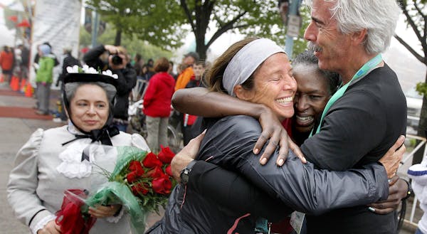 Grandma&#x2019;s Marathon women&#x2019;s winner Sarah Kiptoo, middle right, got hugs from her coaches, Vanessa and Scott Robinson of New Mexico, after