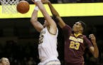 Michigan forward Ricky Doyle (32) loses control of the ball as he is fouled by Minnesota forward Charles Buggs (23) during the first half of an NCAA c