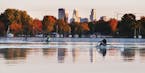 Trees were ablaze in fall colors and the Minneapolis skyline glowing at dawn as rowers in single sculls glided across a still Lake Nokomis Thursday in