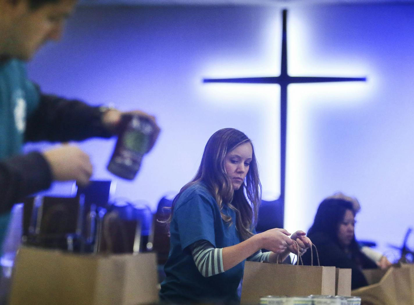 Volunteers Melissa Cotch of Richfield, center, and her husband Bryan, left, bagged Thanksgiving fixings to be given out with a turkey to families in need Tuesday, Nov. 25, 2014, at Union Gospel Mission in St. Paul, MN.](DAVID JOLES/STARTRIBUNE)djoles@startribune Volunteers and staff members at Union Gospel Mission in St. Paul have mobilized and on their way to handing out Thanksgiving Day meals to 50,000 families.**Melissa Cotch, Bryan,cq