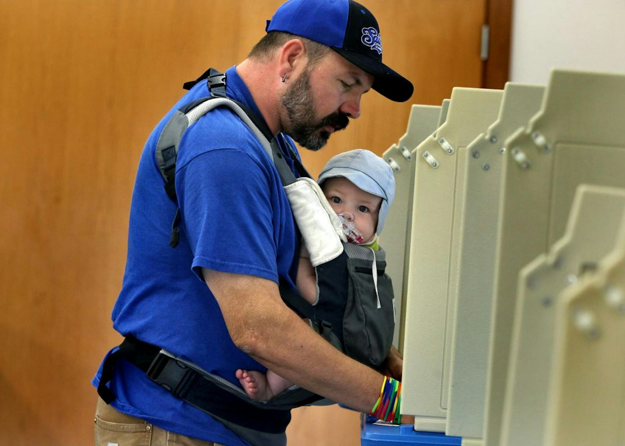 Eight-month-old Maxfield Rymer got his first voting experience with his dad Craig Rymer at the Brackett Park Pavillion in Minneapolis.