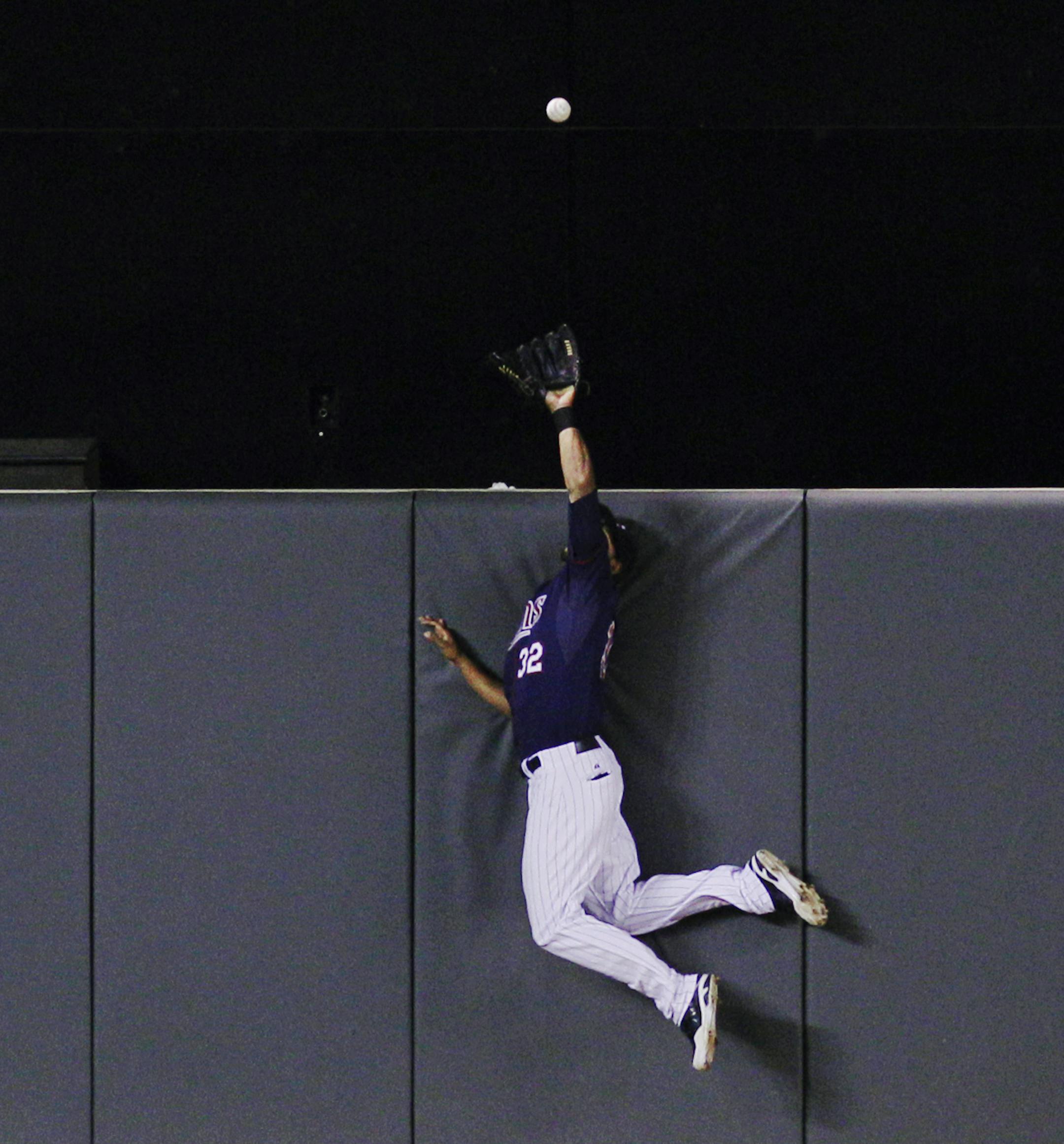 Minnesota Twins center fielder Aaron Hicks makes a leaping catch against Chicago White Sox's Adam Dunn's fly to center during the sixth inning of a baseball game, Monday, May 13, 2013, in Minneapolis. (AP Photo/Genevieve Ross)