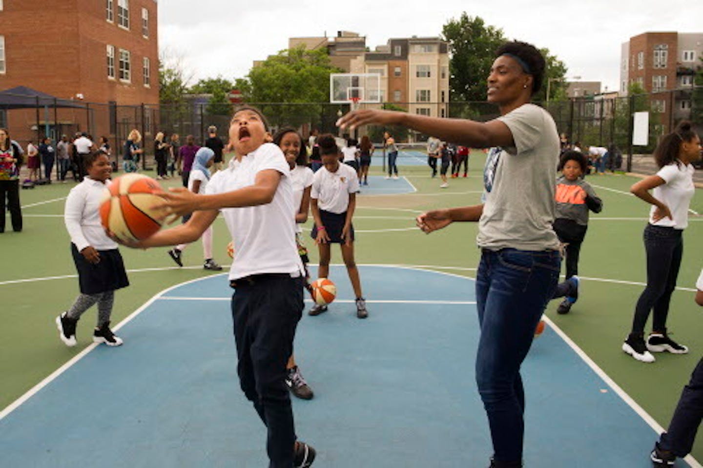 WNBA Champion Minnesota Lynx' Lynetta Kizer watches a student do a layup at Payne Elementary School in Washington, Wednesday, June 6, 2018. Payne Elementary has the highest homeless student population in Washington. (AP Photo/Cliff Owen)