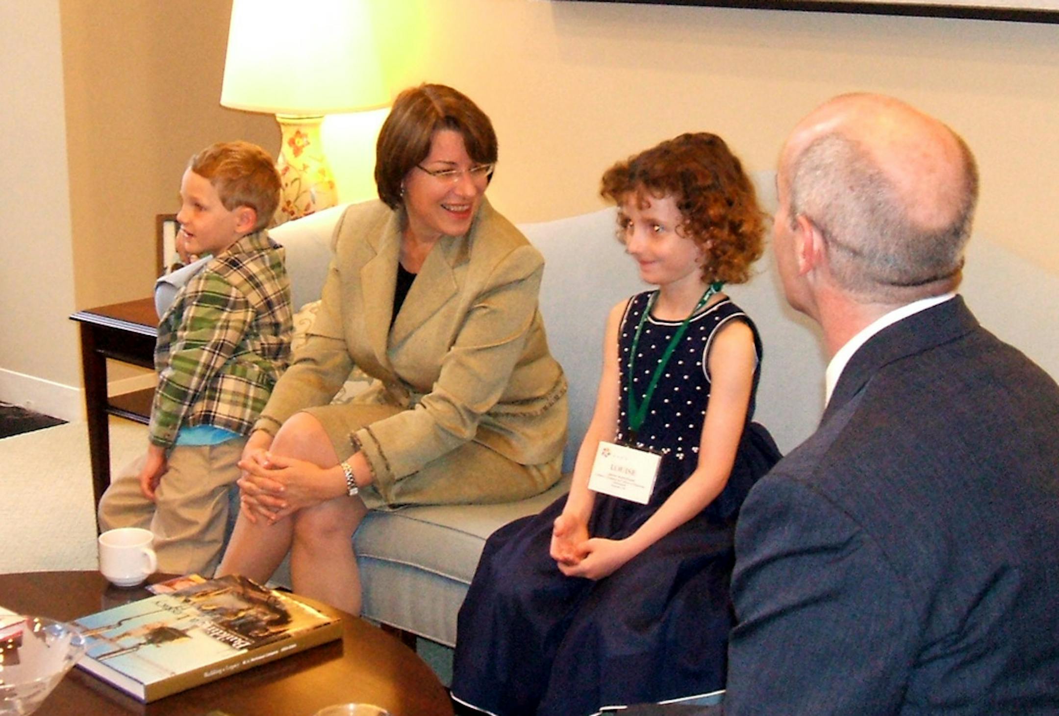 Louise Rosenbaum (at right) and her brother Sam Rosenbaum (left) meet with Sen. Amy Klobuchar during the 2009 National Association of Children's Hospitals Family Advocacy Day. From left to right: Sam Rosenbaum, Sen. Amy Klobuchar, Louise Rosenbaum and Scott Rosenbaum (his back is to the camera).