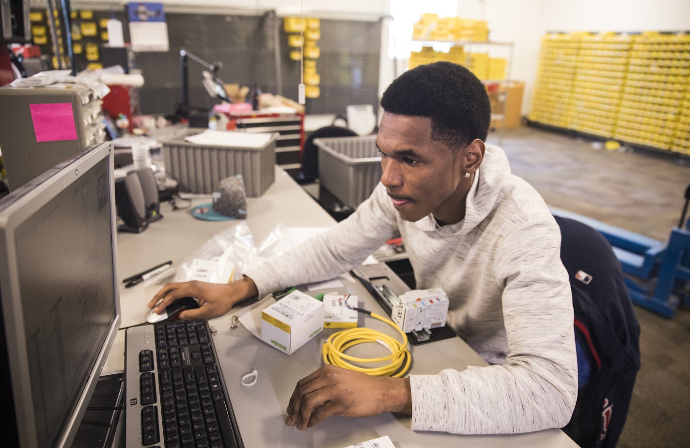 Kamonty Wade, a Summit Academy graduate, works on building an ethernet hub box at Rudolph Technologies. Summit Academy is one of the schools training more women and people of color to work in building trades and technology.