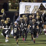 The East Ridge High School Raptors football team takes the field before playing rival Woodbury in 2015.