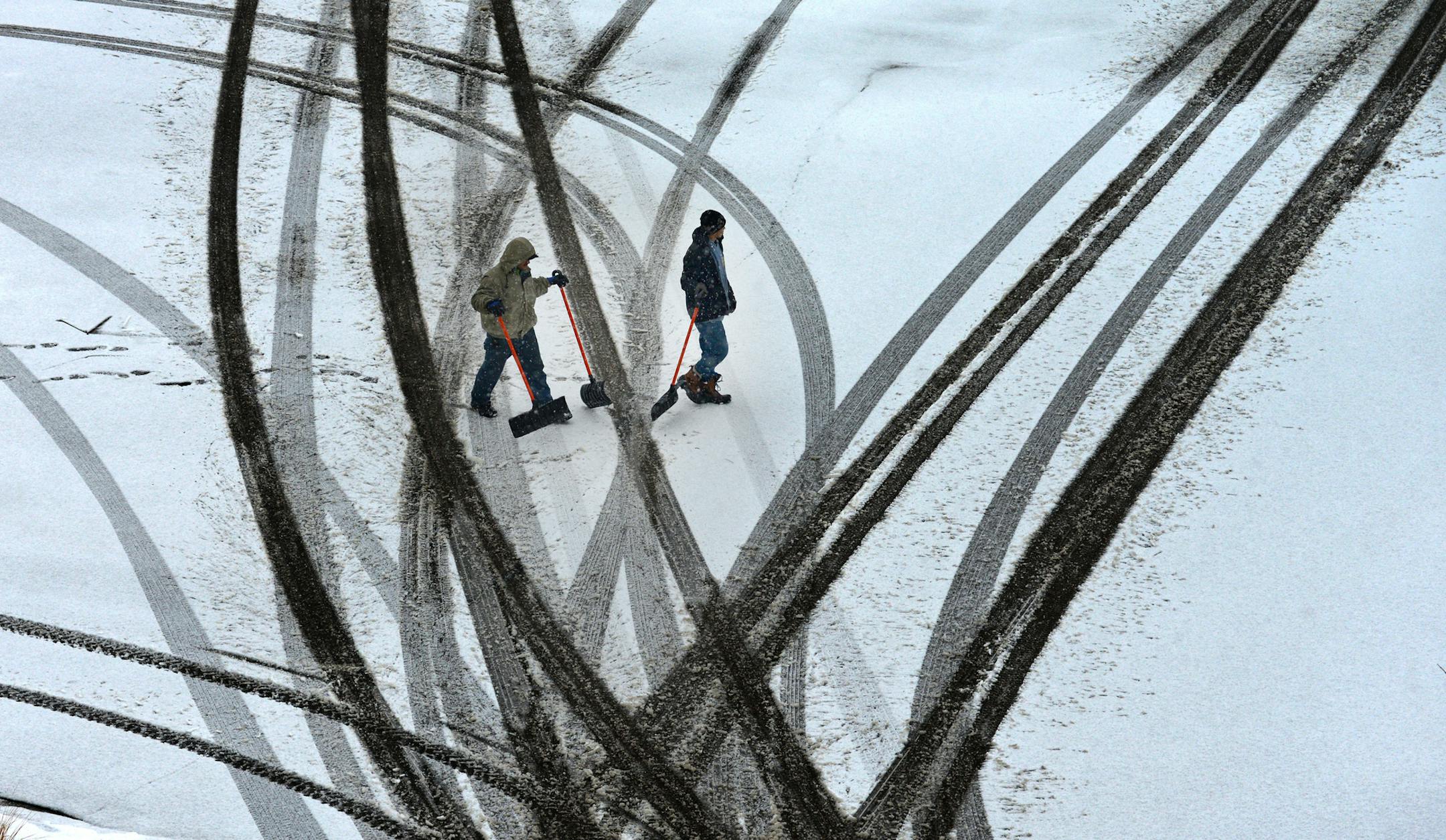 Gelberto Molina and Luis Castro make tracks across the SouthWest Transit Station parking lot in Eden Prairie Minn. on the way to clear sidewalks of snow . ] Richard.Sennott@startribune.com Richard Sennott/Star Tribune Eden Prairie , Minn Thursday 2/20/2014) ** (cq)