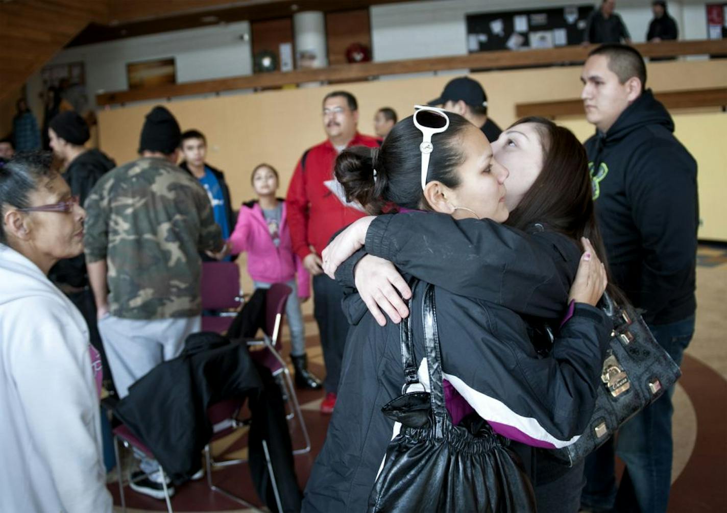 Former Red Lake students Ashley Lajeunesse, left, and Leah Cook, who were in a deadly 2005 school shooting, hugged each other Wednesday during a drum ceremony held in their honor in Minneapolis. They said the drums always remind them of the shots in the hallways of their school seven years ago.