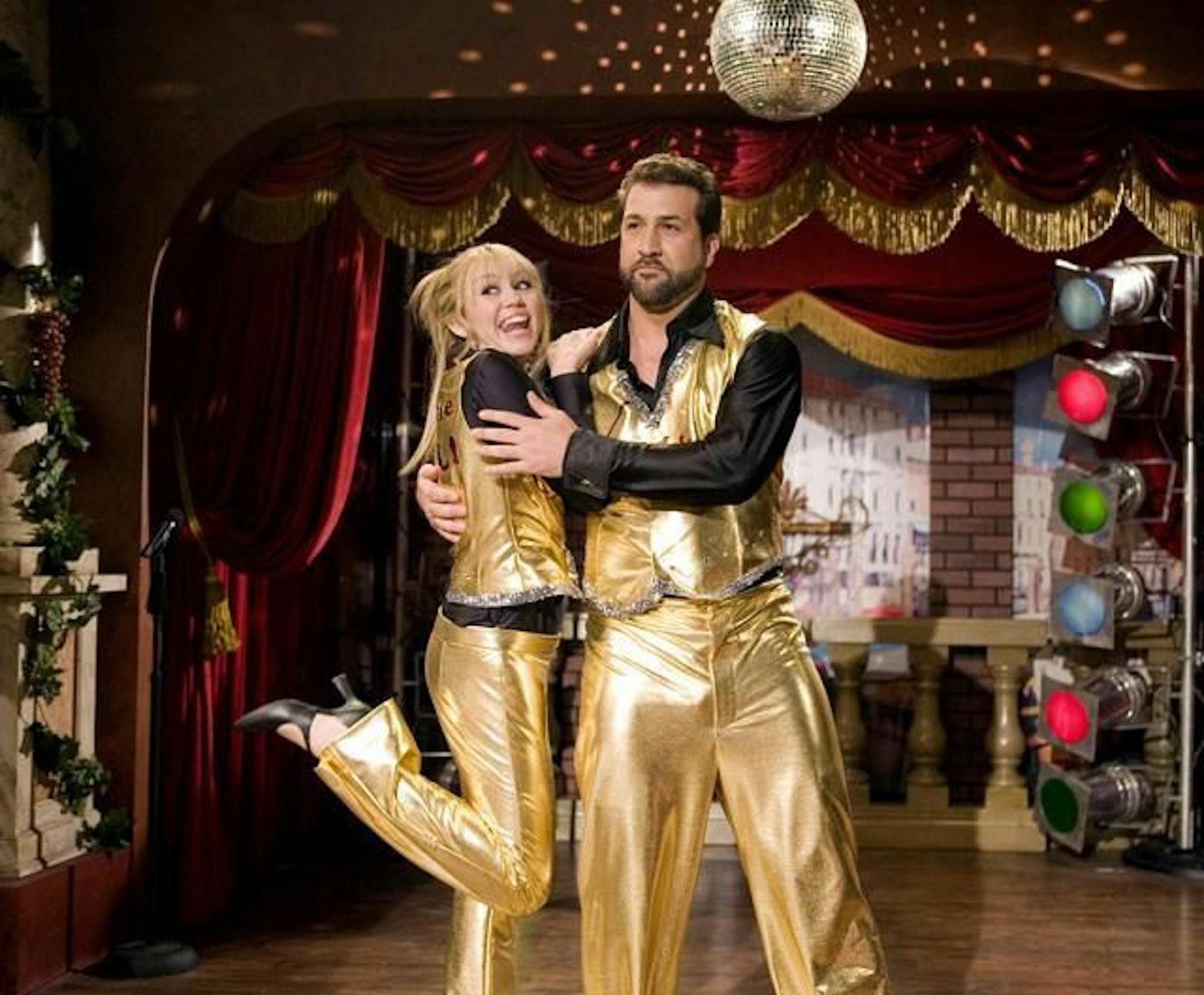 HANNAH MONTANA - "Bye Bye Ball" - Miley tracks down former baseball star Joey Vitolo in hopes of getting his signature after accidentally ruining Jackson�s autographed baseball. The ball player, who currently runs a dinner theatre, convinces Hannah to perform a duet with him in return for the signature, on "Hannah Montana" airing FRIDAY, JANUARY 13 (8 p.m., ET) on Disney Channel. (DISNEY CHANNEL/JOEL WARREN) MILEY CYRUS, JOEY FATONE