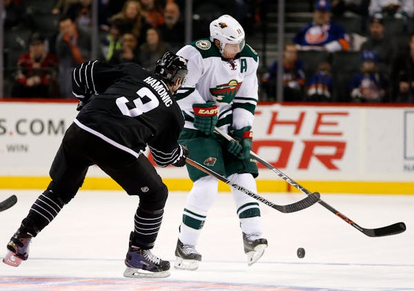 Minnesota Wild left wing Zach Parise (11) defends as New York Islanders defenseman Travis Hamonic (3) passes the puck during the third period of an NH