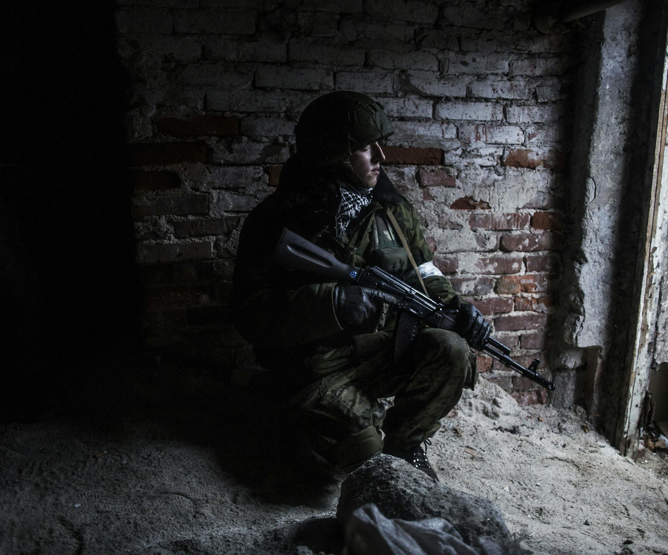 A Russian backed separatist rebel takes cover in a shelter from shelling in the Kievsky district, 3 km from the Airport, in Donetsk, Ukraine, Thursday, Jan. 22, 2015. A mortar shell hit a bus in the eastern Ukrainian rebel stronghold of Donetsk on Thursday, killing at least 13 people, the separatist leader in the city said. It was unclear immediately which side was responsible for the attack, which killed passengers instantly and blew out the windows of a nearby building. (AP Photo/Manu Brabo)