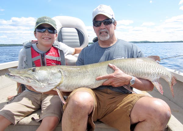 Don Pereira hooked this muskie on Lake Vermilion and let his son, 15-year-old Leo Pereira, left, reel it in.