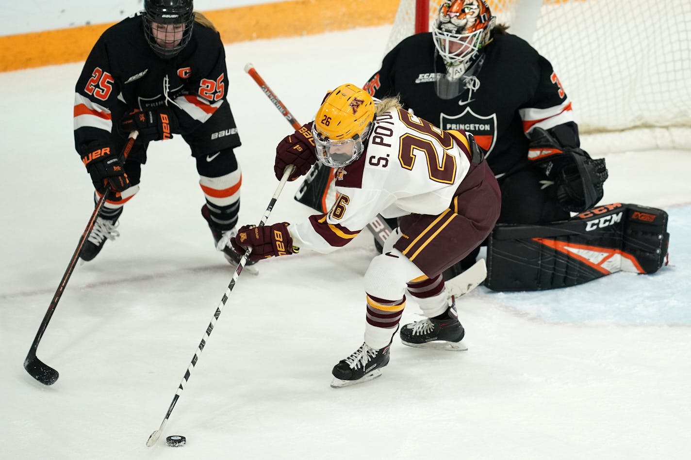 Gophers forward Sarah Potomak (26) tried to turn the puck to get a shot off on Princeton goaltender Steph Neatby