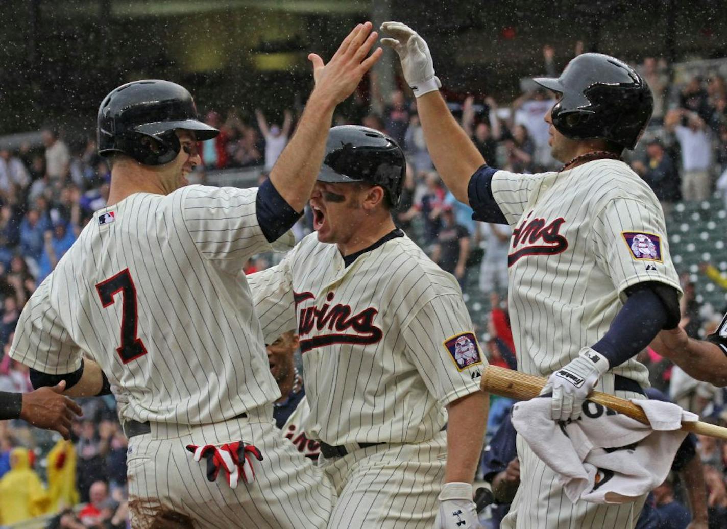 (left to right) Joe Mauer celebrated the winning run on a Ryan Doumit triple, with Chris Parmelee and Chris Colabello in 9th inning action.