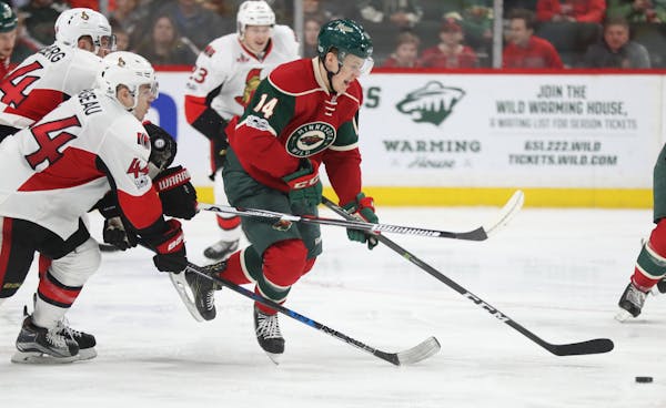 Joel Eriksson Ek(14) tries to get away with the puck.]At the Xcel Energy Center in a game between the Wild and Ottawa.Richard Tsong-Taatarii/richard.t
