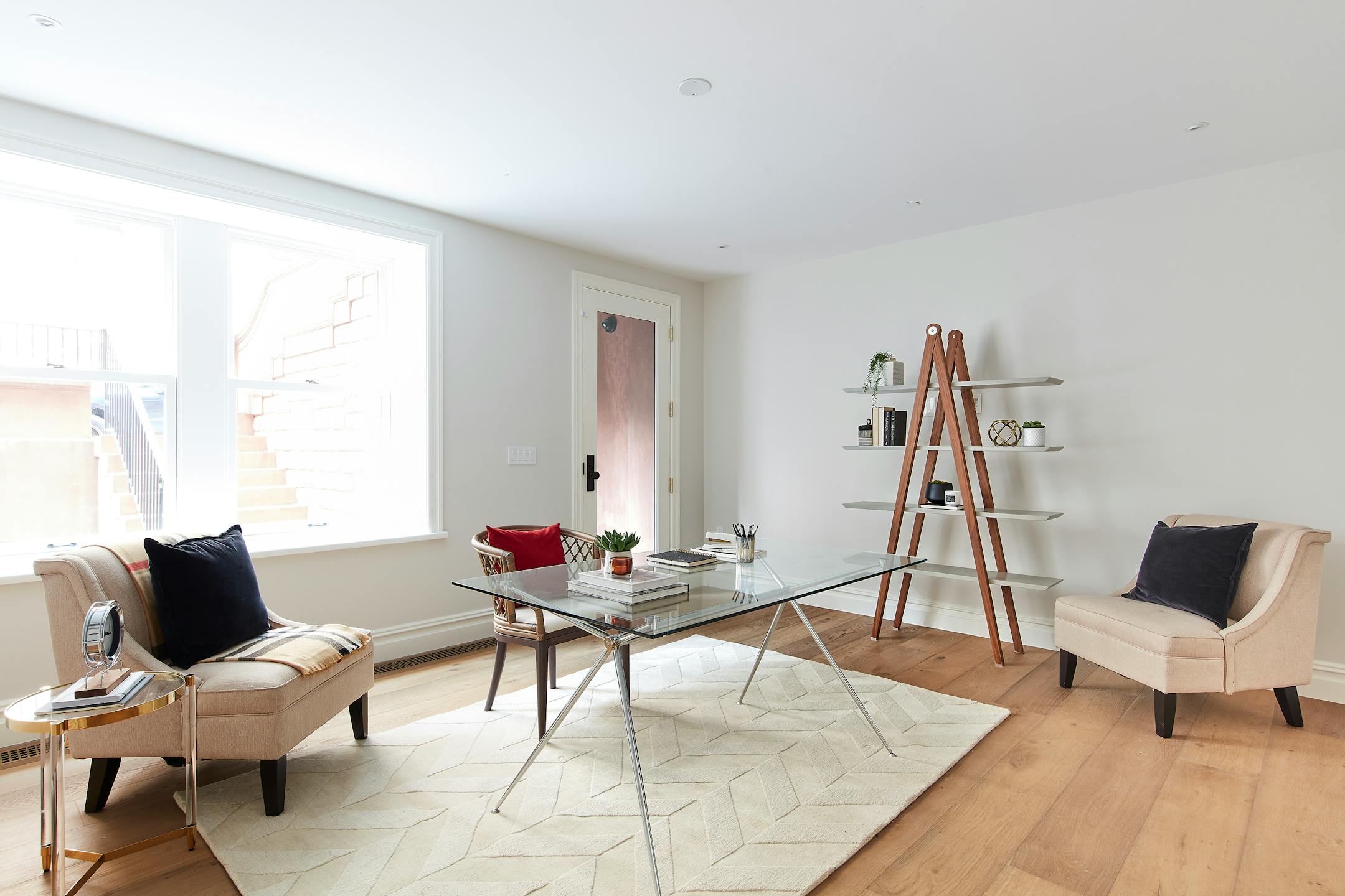 A below grade space is lightened through the use of transparent surfaces and light fabrics and textiles. (Scott Gabriel Morris/TNS)