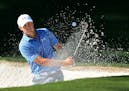 Jordan Spieth chips out of a bunker at the 10th green during the third round of the Masters at Augusta National Golf Club on Saturday, April 11, 2015,