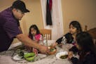 At their home in the Phillips neighborhood, Victor Soberanes, who is serving dinner to his daughter Viannay,4, niece Yeili,8, and daughter Xochitl,6(L