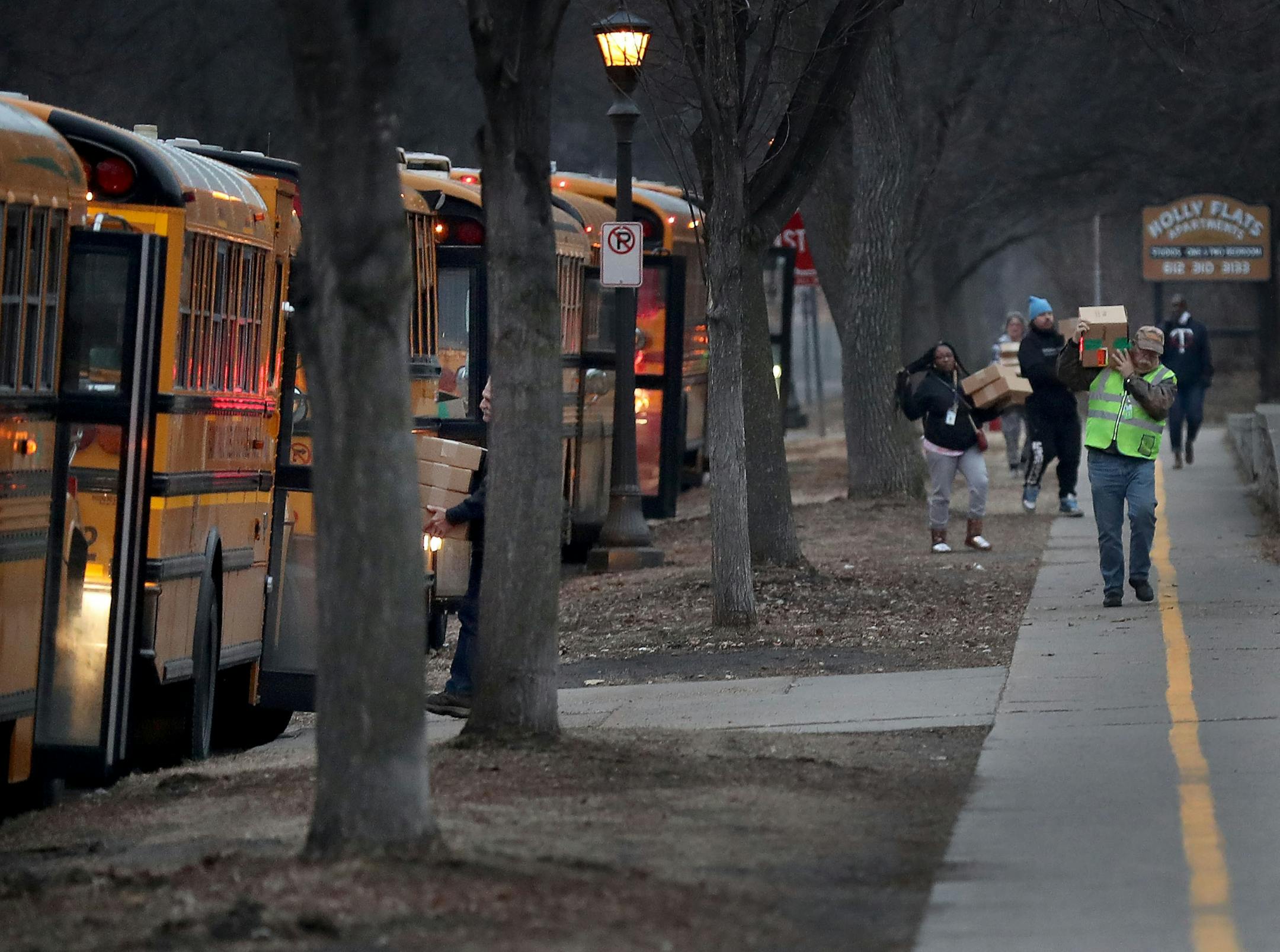 St. Paul school bus drivers and aides headed out with a week's worth of breakfasts and lunches to families of students along its route Wednesday, March 25, 2020, in St. Paul, MN. Here, bus drivers and aides carried meals not picked up during the early morning bus run to buses going out from Obama Elementary School.