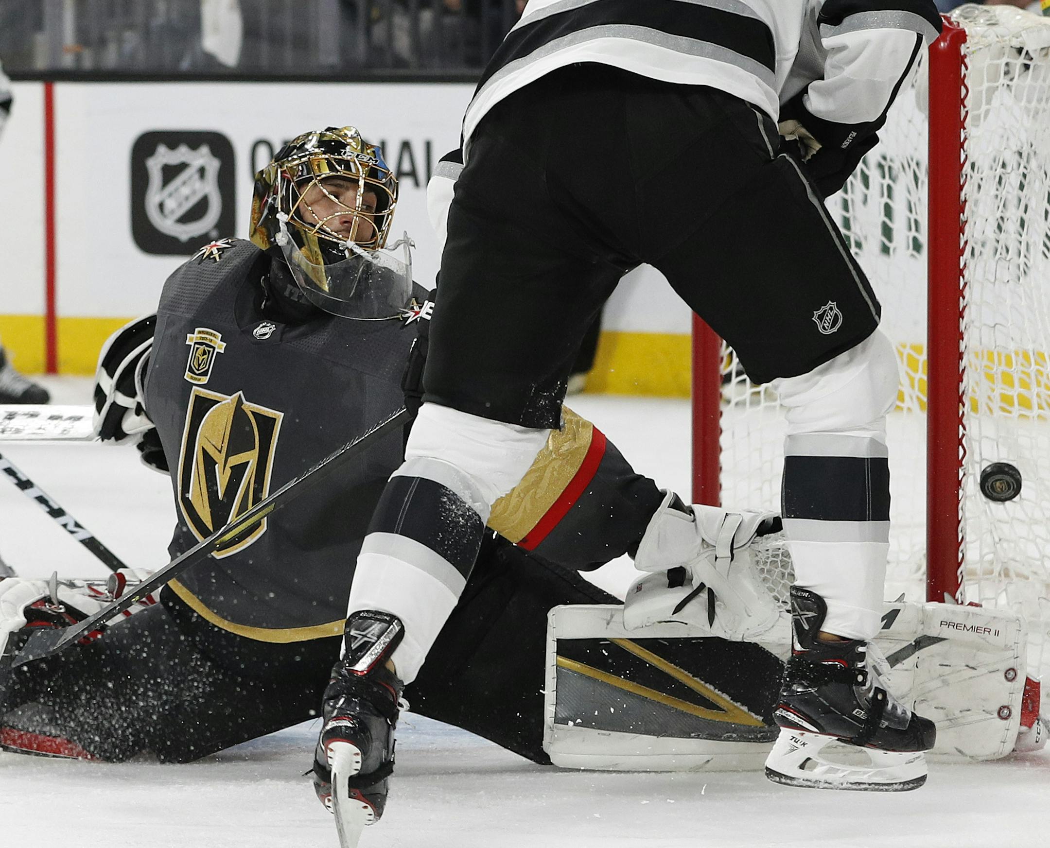 Vegas Golden Knights goaltender Marc-Andre Fleury blocks a shot next to Los Angeles Kings left wing Tanner Pearson during the third period of Game 1 of an NHL hockey first-round playoff series, Wednesday, April 11, 2018, in Las Vegas. The Golden Knights won 1-0. (AP Photo/John Locher)
