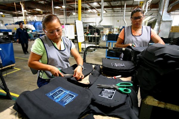 Workers in Costa Mesa, Calif., covered plates with fabric at the assembly plant of Ceradyne, which makes ceramic body armor for soldiers.