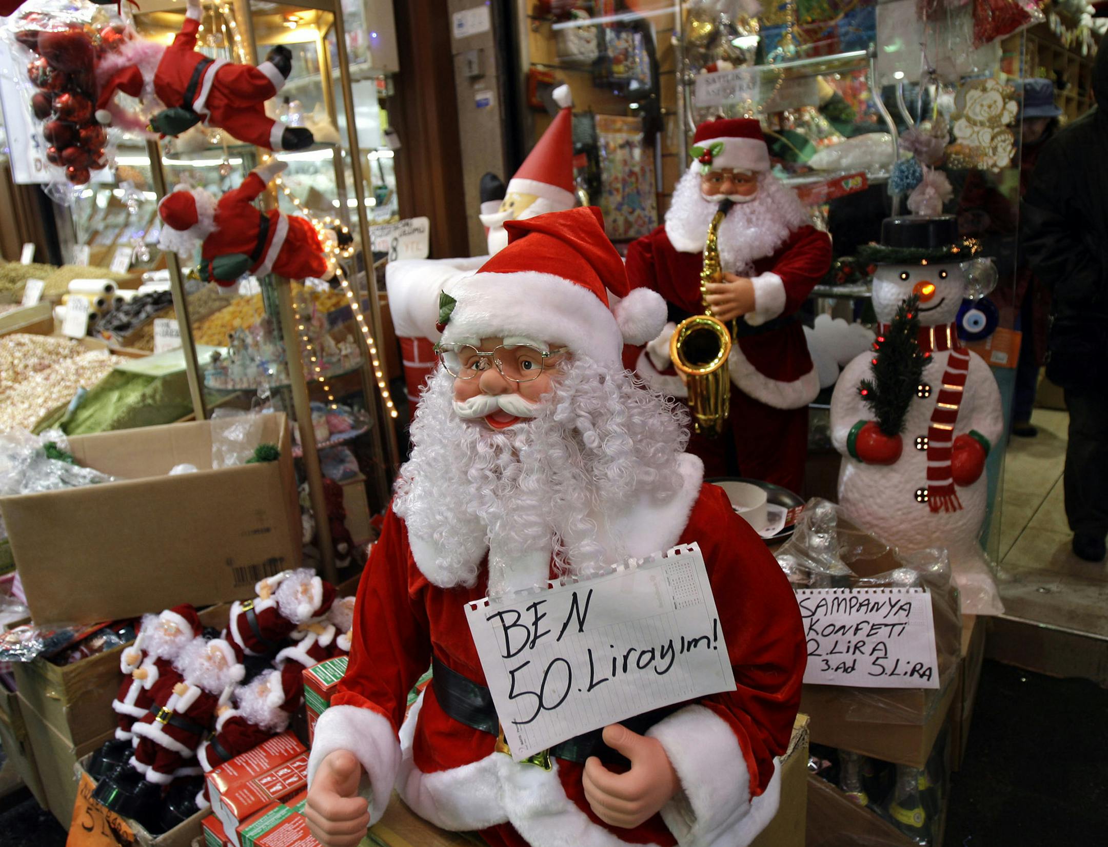 A Turkish woman looks at Christmas ornaments at a gift shop in Istanbul, Turkey, Wednesday, Dec. 24, 2008. Even in predominantly Muslim Turkey, Christmas has evolved as a prime time shopping season as Turks joyfully celebrate New Year's Eve with special dinners and exchanging gifts with their loved ones. On the price tag of Santa Claus reads that: "I am 50 Liras!". (AP Photo/Murad Sezer) ORG XMIT: IST101