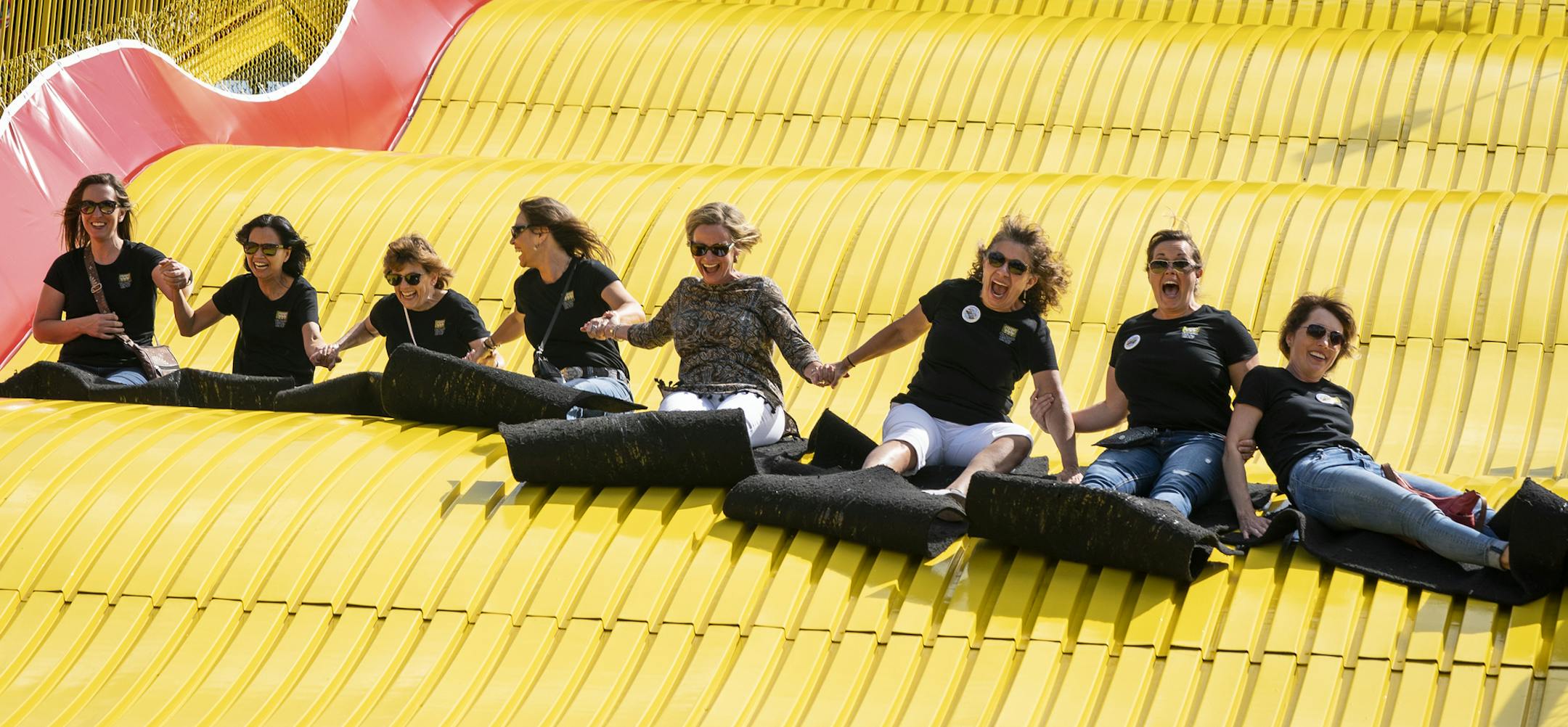A group of women from Orchard Dental Group flew down the State Fair's Giant Slide together Thursday. This is the 50th year of the Giant Slide at the fair.