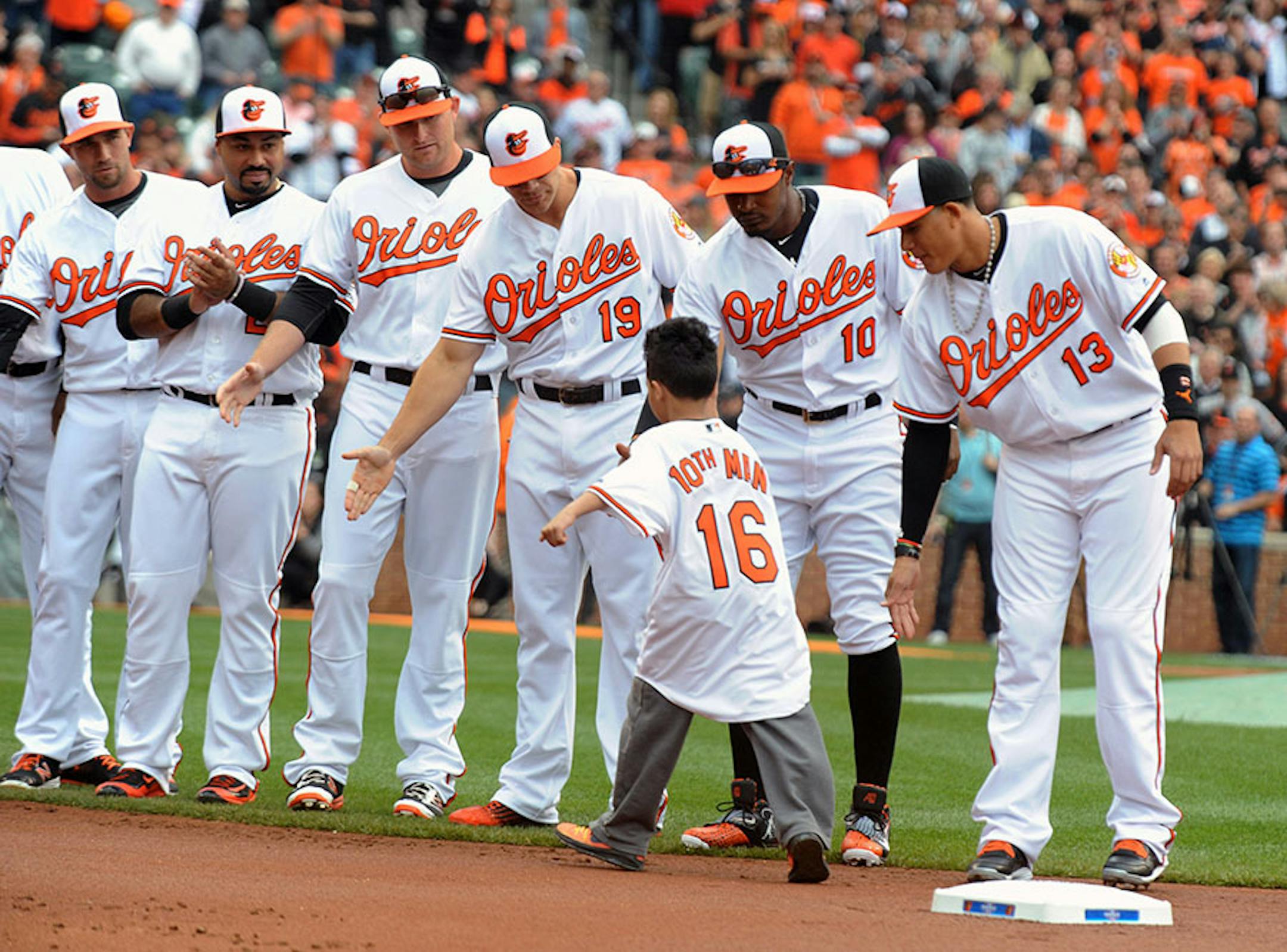 Baltimore Orioles 10th man Avery Ray, 7, is greeted by Orioles players during a pregame ceremony on opening day on Monday, April 4, 2016, at Oriole Park at Camden Yards in Baltimore. (Kenneth K. Lam/Baltimore Sun/TNS) ORG XMIT: 1182892