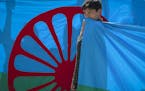 A boy holds a Roma flag during an anti-racism march by members of the Romanian Roma community celebrating the Romani Resistance Day in Bucharest, Roma