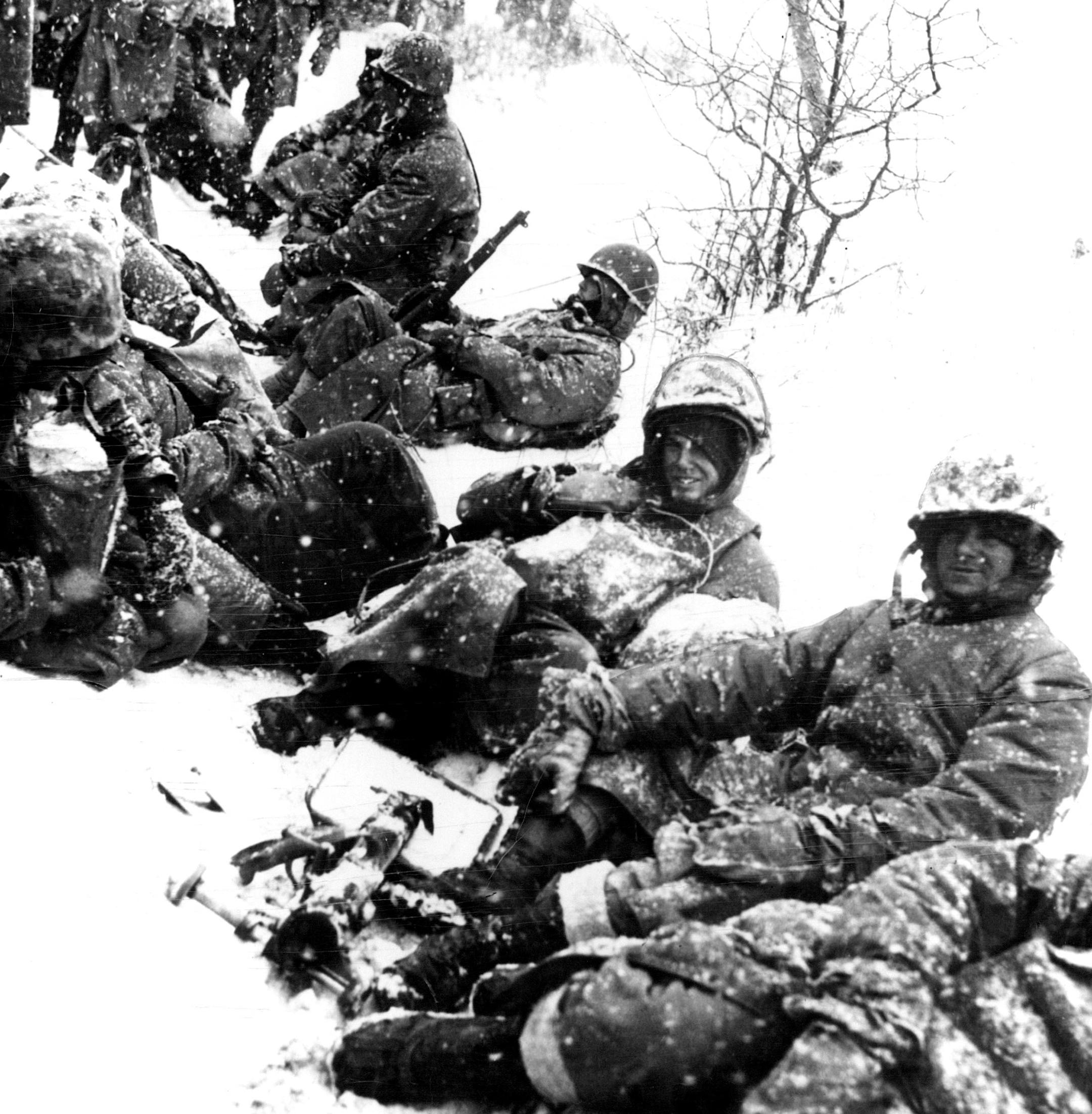 December 26, 1950 Rest Along A Korean Roadside-This group of weary United States marines is shown taking a breather along a snow-bound road in Korea. They'd just left Kodari. December 25, 1950 Minneapolis Star Tribune; International News Photos