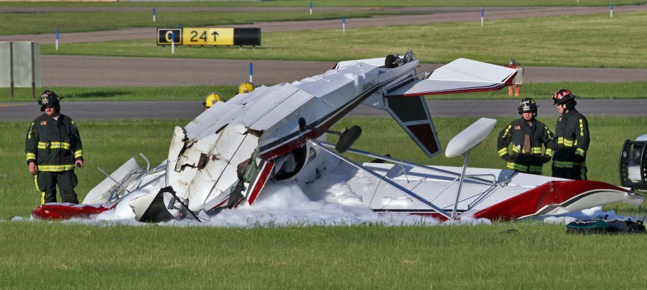Fire personnel observe the wreckage.