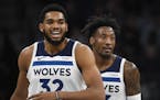 Minnesota Timberwolves center Karl-Anthony Towns (32) and forward Robert Covington (33) walked back to the bench after a New Orleans time out in the f