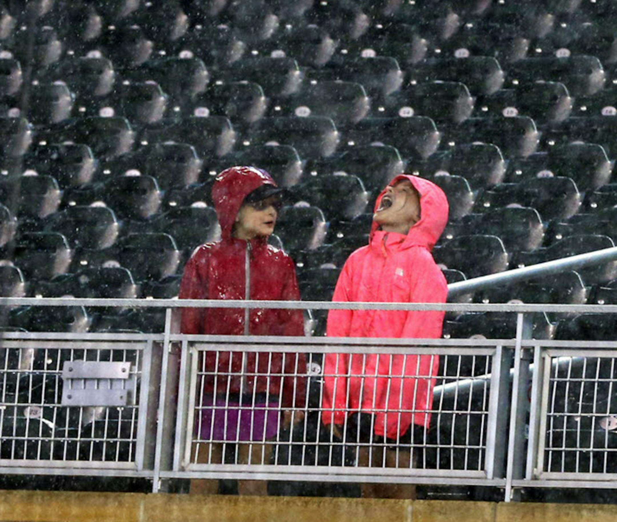 A child opened her mouth skyward to catch the rain during Wednesday night's long rain delay at Target Field. The Twins game with Houston was postponed, creating a day-night doubleheader Thursday.