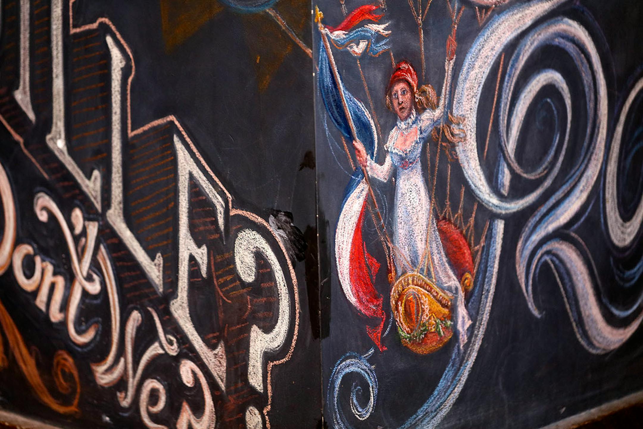 Adam Dennis work at Coup d'Etat restaurant in Uptown. Dennis' work include Smack Shack and the Pourhouse and is done with chalk and spray paint.