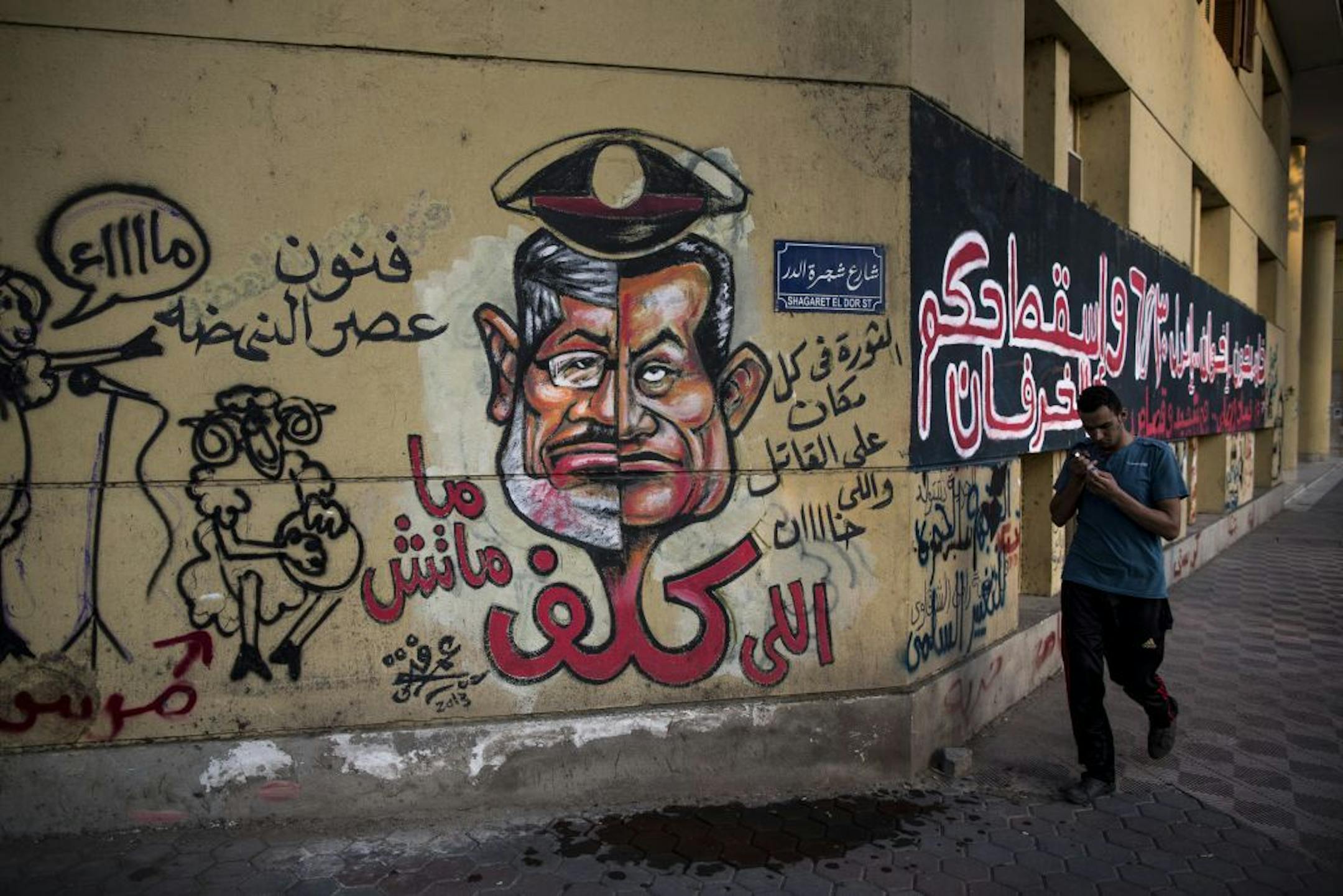 Graffiti shows the face of ousted Egyptian president Mohammad Morsi, left, and former President Hosni Mubarak blended together in Cairo, Aug. 20, 2013.