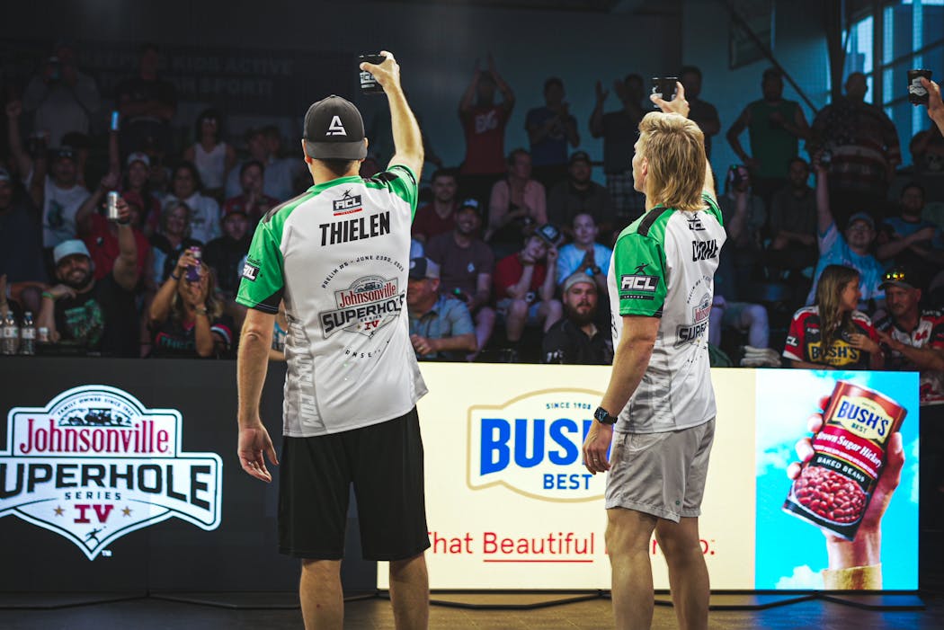 Professional cornhole player Josh Thielen and TV personality Kyle Cooke raise a toast to their fans at the ACL Superhole Prelim, hosted in Ramsey, Minn. on June 23.