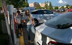 Keli Selness of Wayzata prepared to charge her Tesla before shopping at a Target in St. Louis Park with her husband and two sons last week.