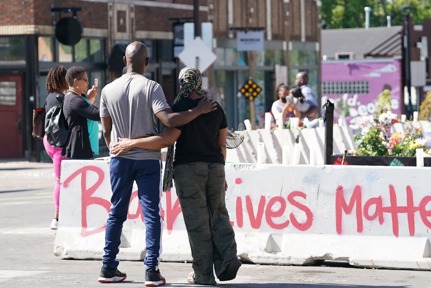 George and Julie Russell of Champlin, Minn., walked through George Floyd Square while visiting relatives in Minneapolis on Friday. The city removed concrete barriers Thursday, but protesters put up makeshift barricades where concrete dividers had stood.