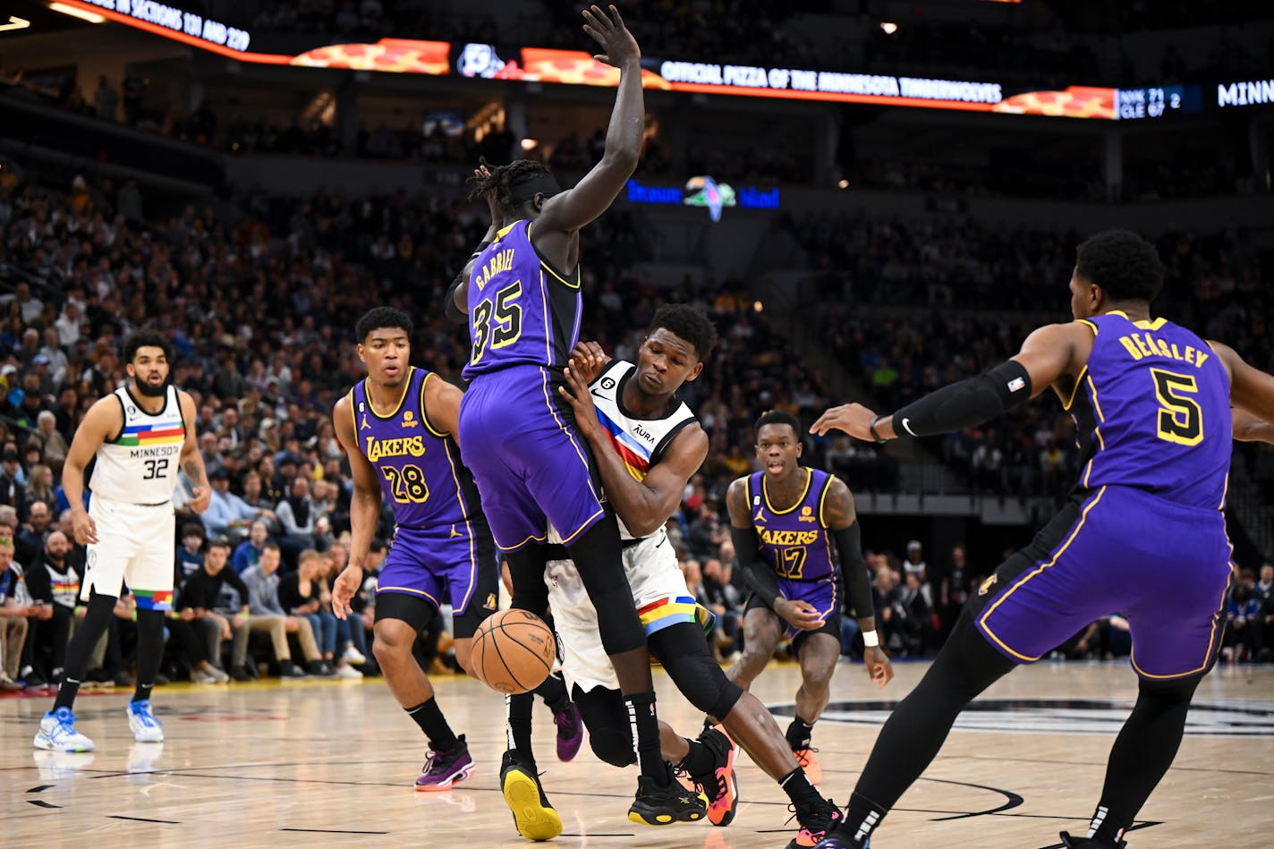 Timberwolves guard Anthony Edwards loses the ball as he collides with Lakers forward Wenyen Gabriel in the first quarter Friday