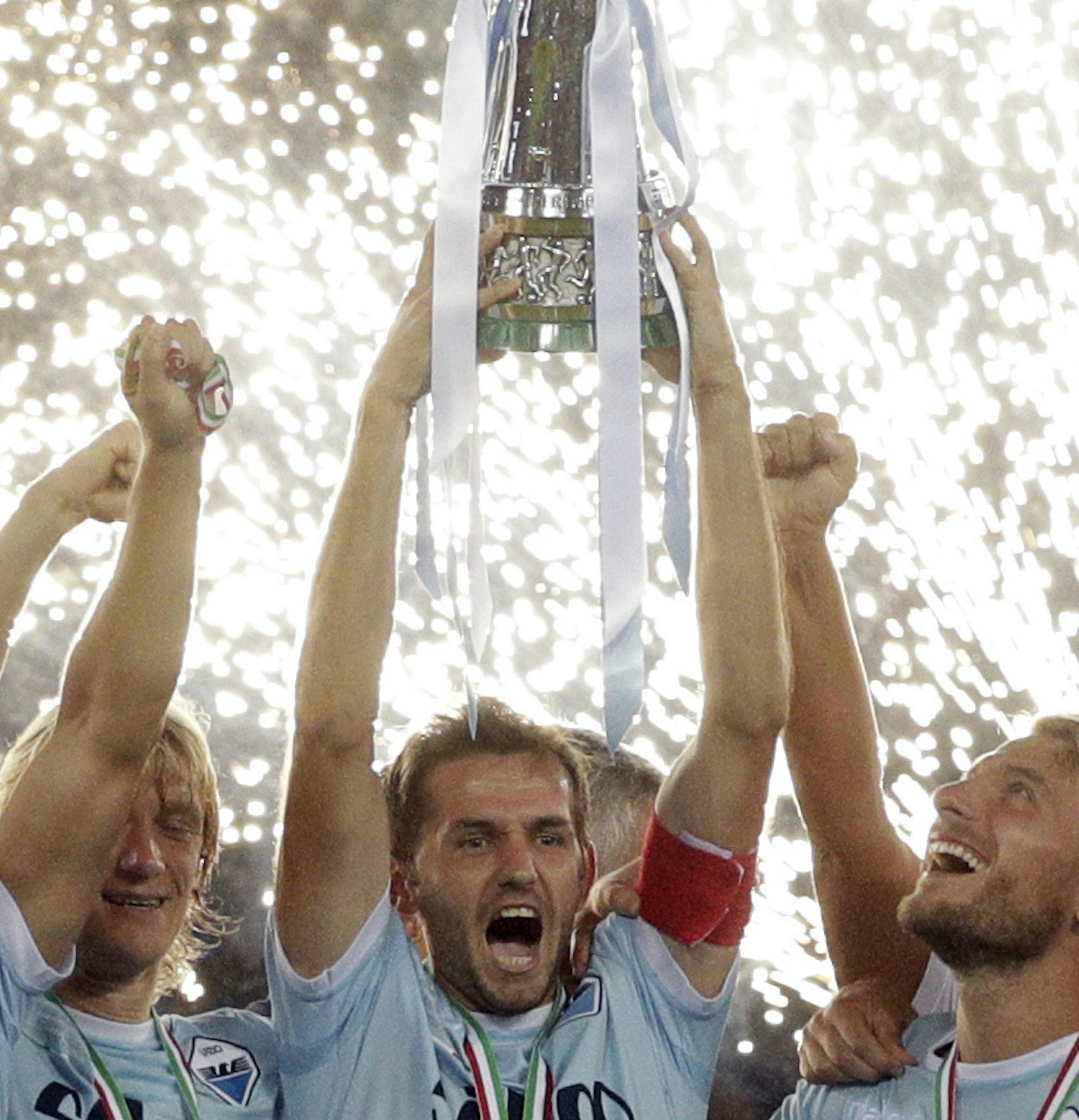 Lazio's captain Senad Lulic, center, raises the trophy at the end of the Italian Super Cup final match between Lazio and Juventus at Rome's Olympic stadium, Sunday, Aug. 13, 2017. Lazio won 3-2. (AP Photo/Gregorio Borgia) ORG XMIT: GB160